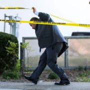 An LMPD detective walks under police tape Monday afternoon on Main Street. Five people were shot and killed, with six injured including an LMPD officer at Old National Bank Monday morning. April 9, 2023
