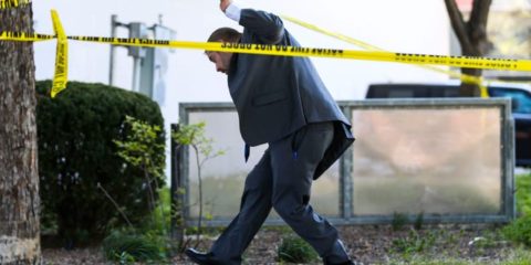 An LMPD detective walks under police tape Monday afternoon on Main Street. Five people were shot and killed, with six injured including an LMPD officer at Old National Bank Monday morning. April 9, 2023